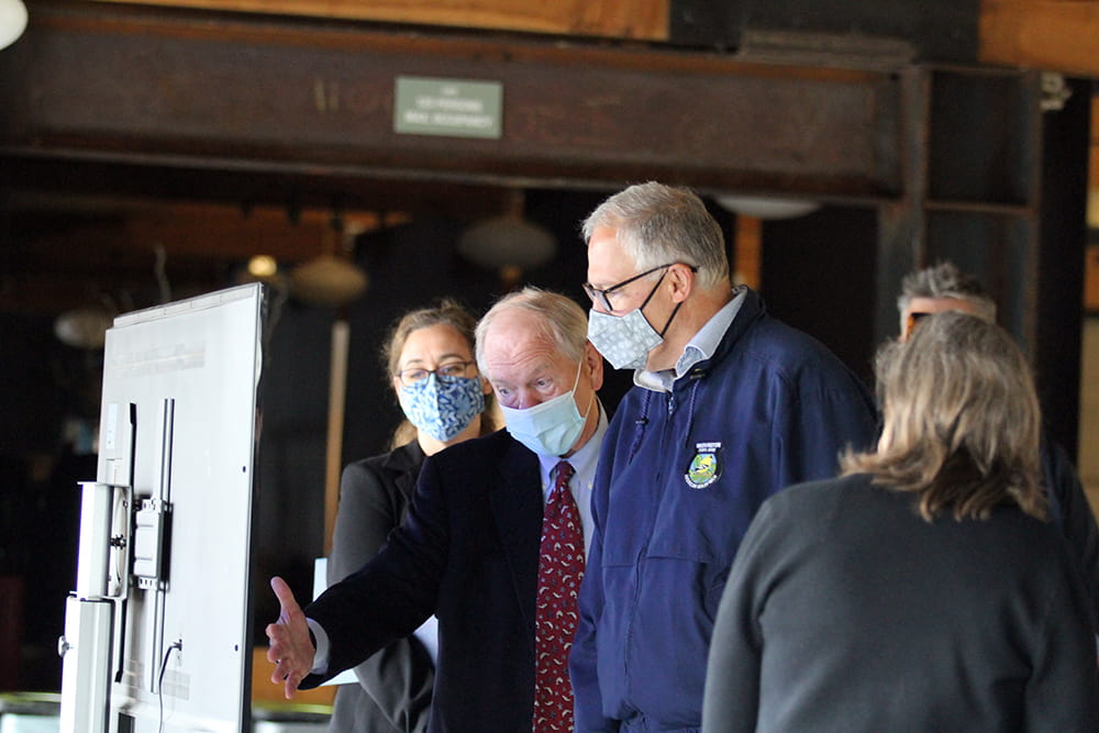 Robert Davidson and Governor Jay Inslee standing in front of a monitor and having a conversation.