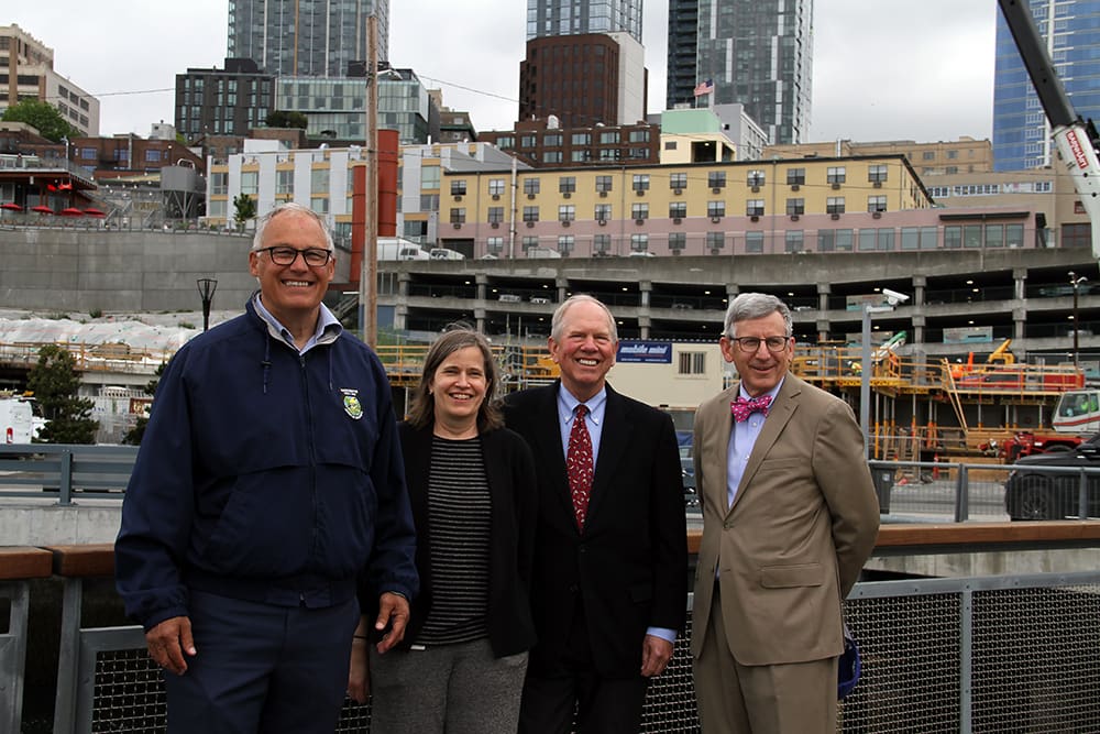 Governor Jay Inslee, Susan Bullerdick, Robert Davidson, and Bob Donegan standing on the pier and smiling.
