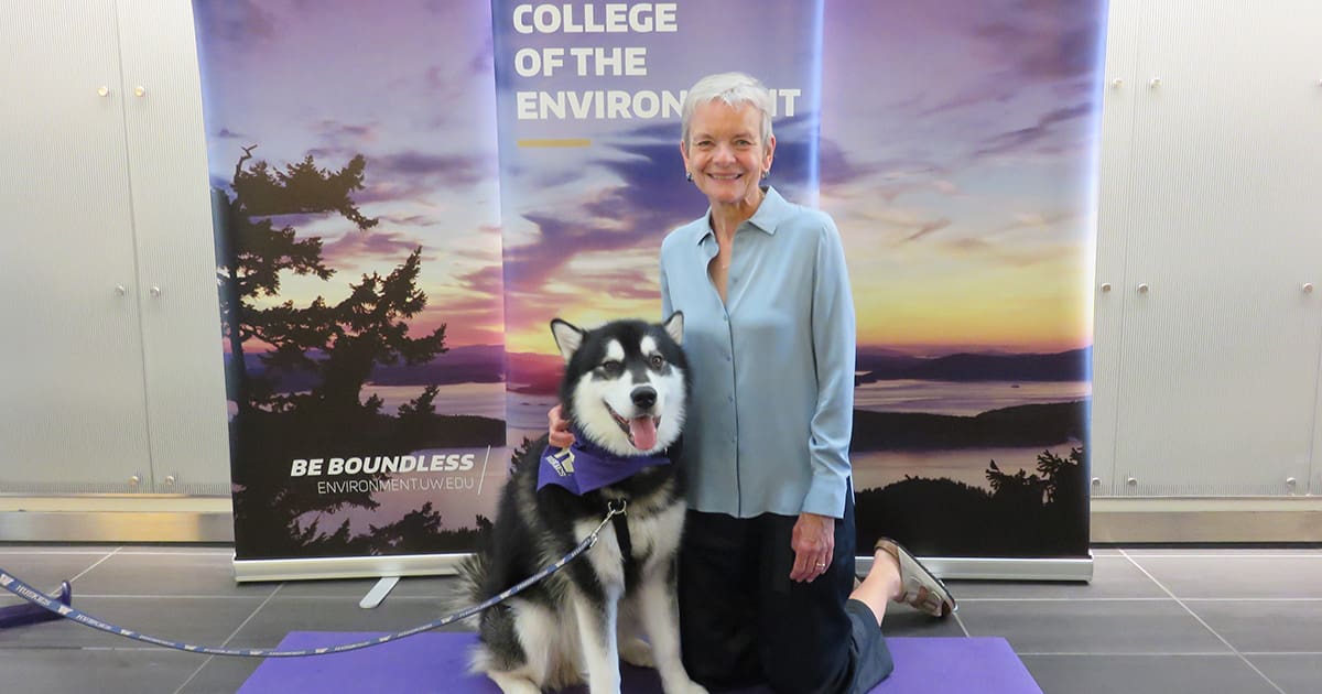 Dr. Lisa Graumlich posing with Dubs, the University of Washington's husky mascot.