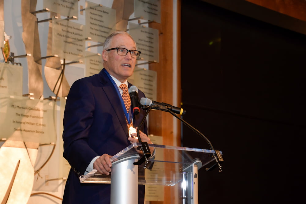 Washington State Governor Jay Inslee standing behind a podium while speaking at the Seattle Aquarium's 2023 Ocean Conservation Honors event.