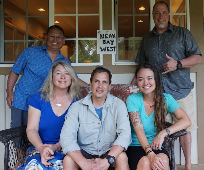 Dr. Shawn Larson, Chris Van Damme, and Amy Olsen sitting on a wicker bench. Alan Tomita and Joel Hollander are standing behind the bench.