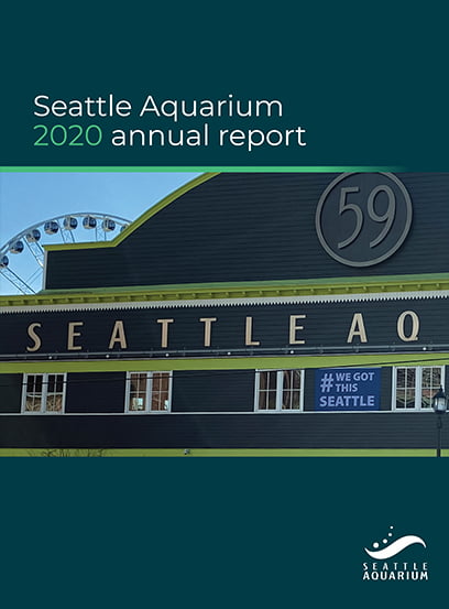 A photo of the outside of the Seattle Aquarium building. A blue banner covering the top third of the image reads "Seattle Aquarium 2020 annual report." A blue banner covering the bottom third of the image contains the Seattle Aquarium logo in the bottom right corner.