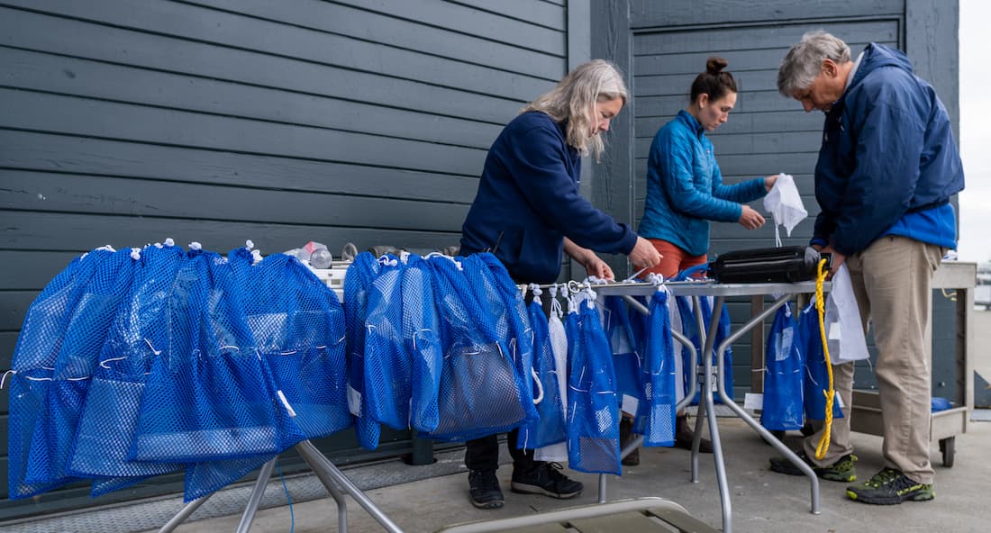 Seattle Aquarium researchers preparing mesh bags containing experimental replacements for thin-film plastics.