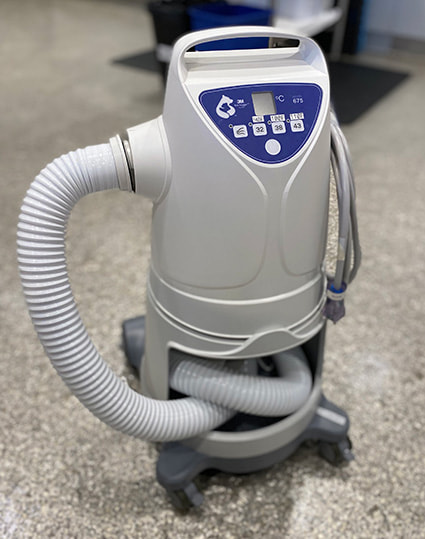 A small machine with buttons and a hose attached used to control different air temperatures.