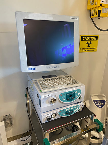 An endoscopy unit with a large viewing screen and keyboard sitting on top of the endoscopy equipment boxes.