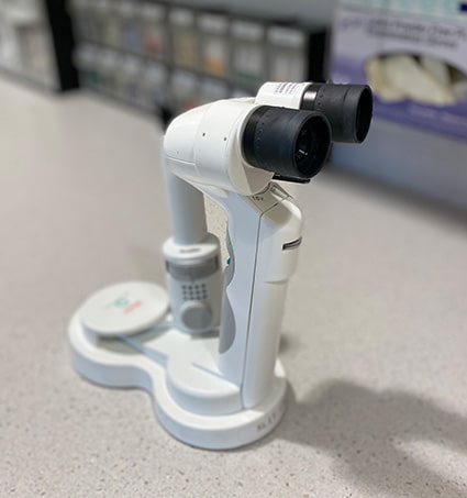 A small handheld microscope attached to a stand on a table.