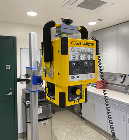 Portable x-ray machine attached to a maneuvering arm.