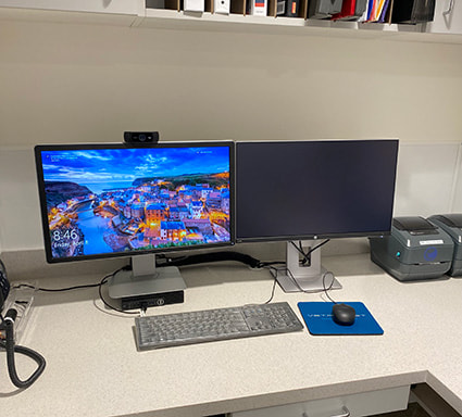 Two computer monitors, a keyboard, and a mouse on a desk.
