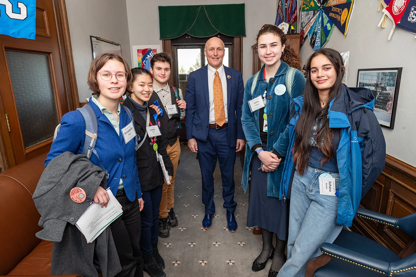 Seattle Aquarium Youth Ocean Advocates posing for a photo with State Representative Steve Bergquist's legislative assistant during a visit to the capitol in Olympia Washington.