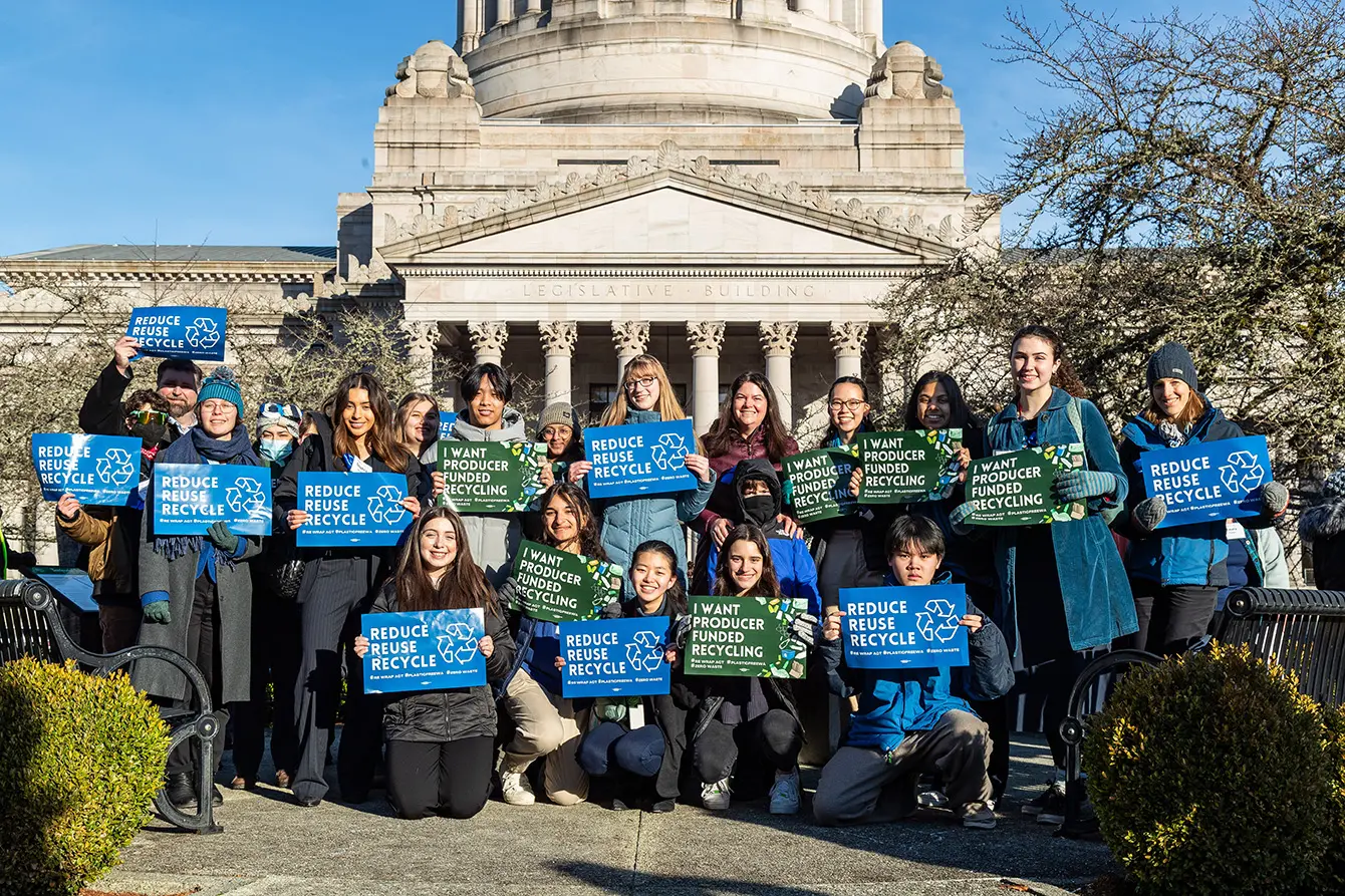 Seattle Aquarium Youth Ocean Advocates and Aquarium staff members pose for a photo outside the legislative building in Olympia Washington while holding signs in support of improved recycling programs and producer funded recycling.