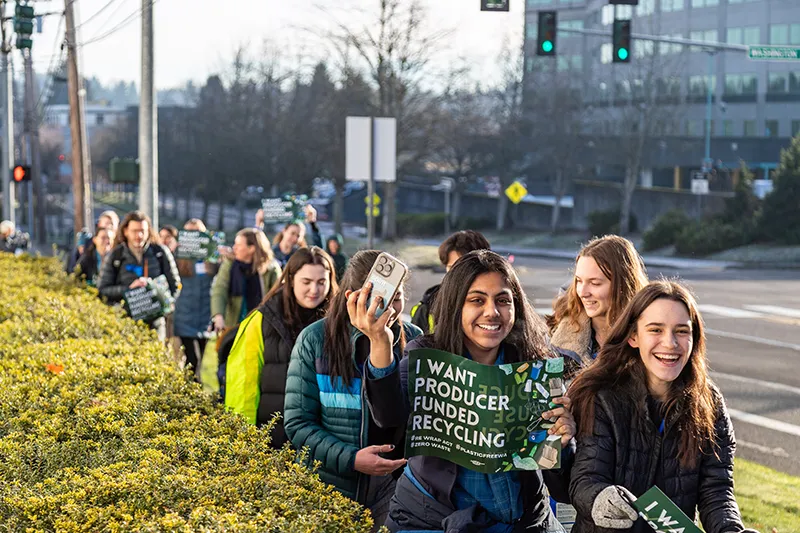 Seattle Aquarium Youth Ocean Advocates march with other Washington State residents along a street in Olympia, Washington, holding signs advocating for improved recycling programs and producer funded recycling.