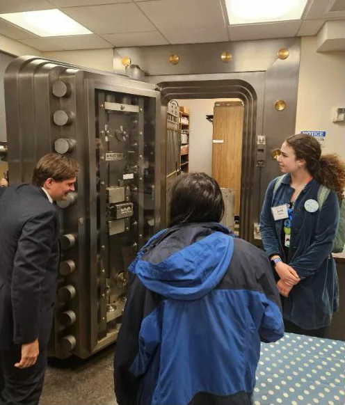 Seattle Aquarium Youth Ocean Advocates looking at a large vault door with Washington State Treasurer Mike Pellicciotti while visiting the capitol in Olympia, WA.