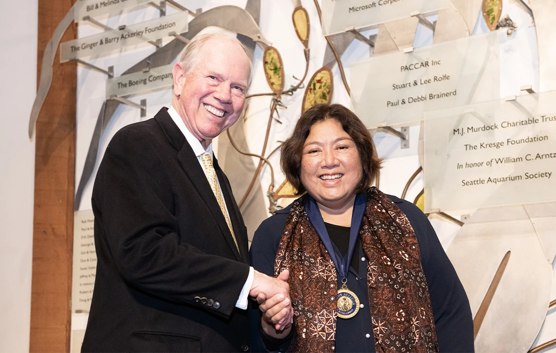 Bob Davidson shakes Rili Djohani's hand after awarding Rili the Sylvia Earle Medal during Seattle Aquarium's 2024 Ocean Conservation Honors event.