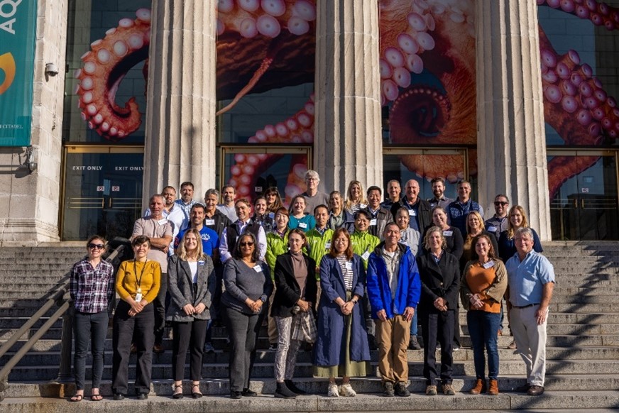 A large group of people standing on the outer steps of the Shedd Aquarium.