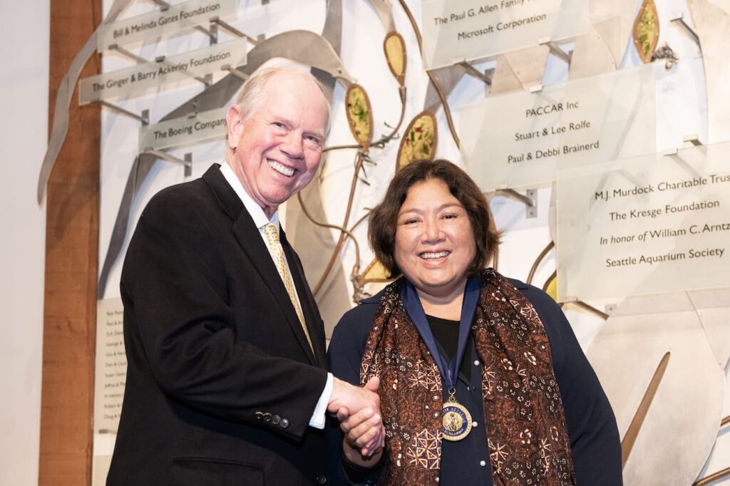 Seattle Aquarium President Bob Davidson shaking hands with Rili Djohani.