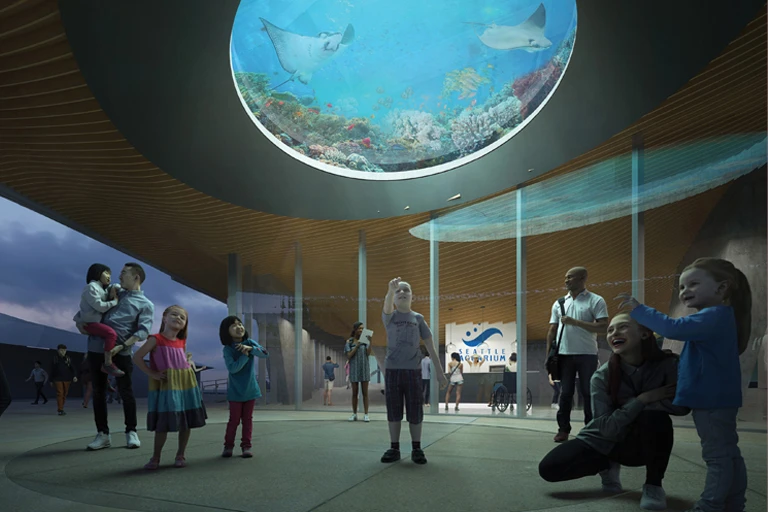 Rendering showing guests outside the front entrance to the new Ocean Pavilion. A small child points up towards the Oculus, a window to a large underwater habitat where tropical fish and rays are shown swimming.