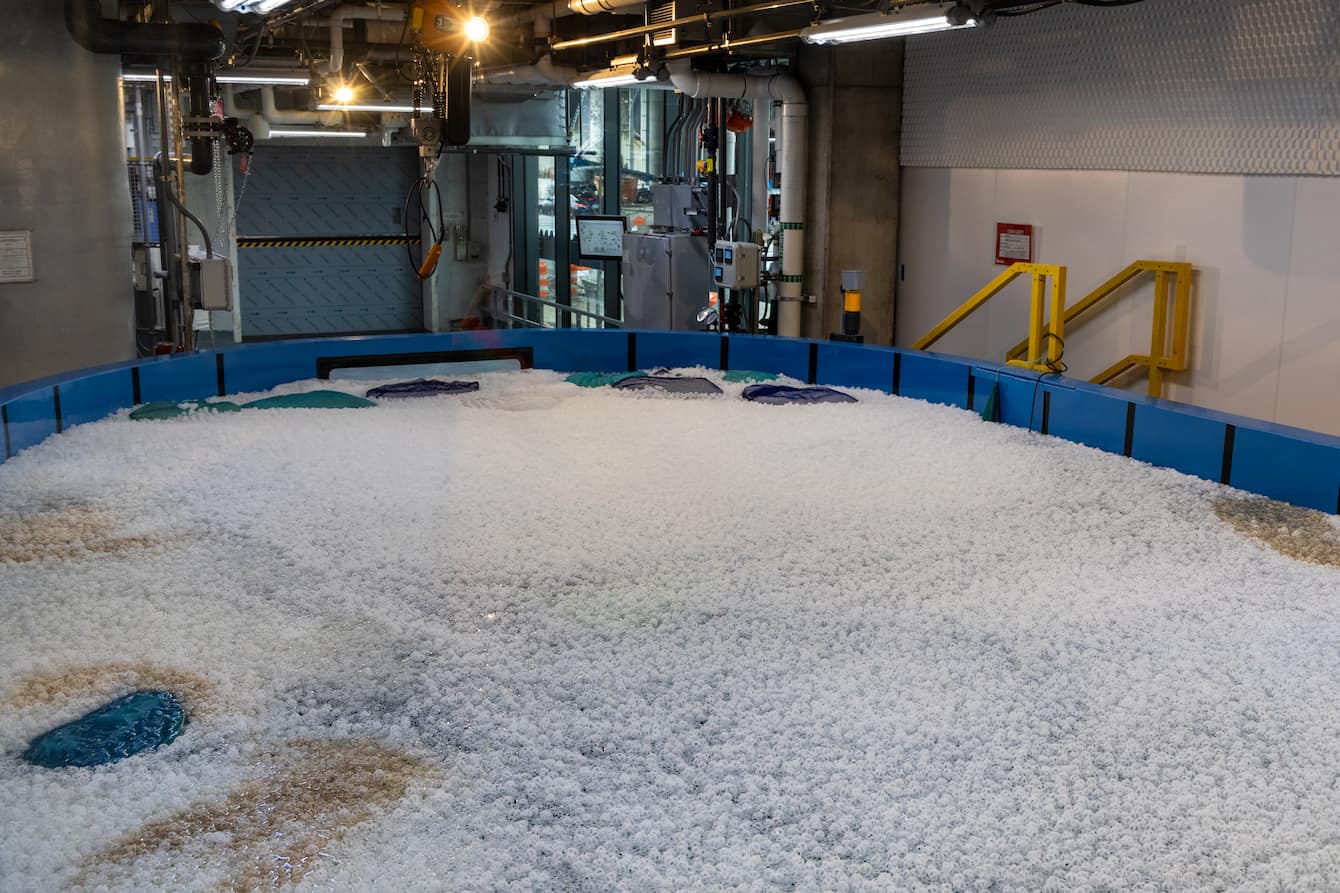 The surface of The Reef habitat, now filled with water, covered in thousands of small, white bio balls.