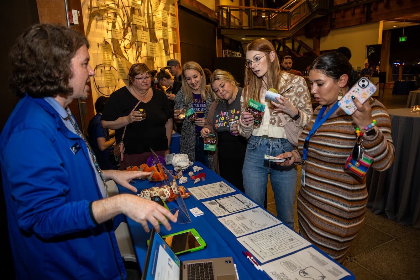 A group of teachers talking with an Aquarium staff member.