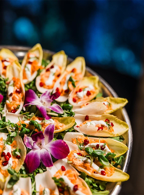 Bite-sized lettuce cup appetizers filled with different foods sitting on top of a decorative platter.