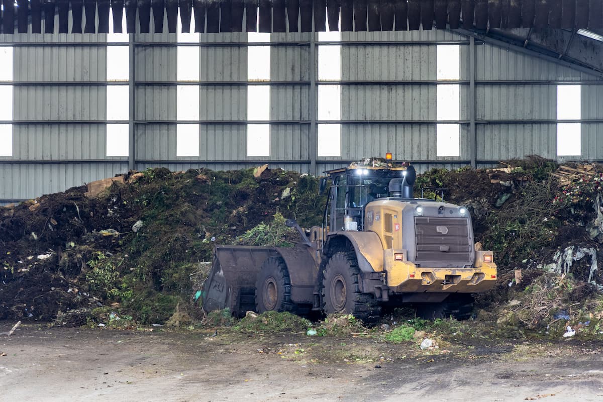 A large truck scooping up food waste.