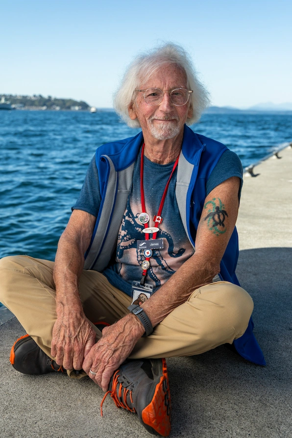 James sitting cross-legged next to the Salish Sea.