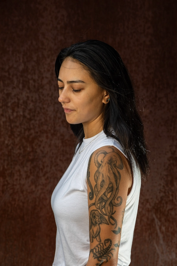 Mia's left arm is covered in black and white tattoos of a seahorse, octopus, rabbit and scorpion.