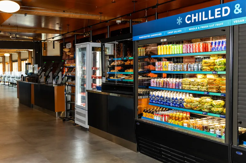 The Seattle Aquarium café featuring a chilled item display of drinks, salads, and ready-made foods, bakery items, and payment systems.