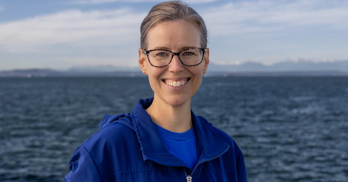Meg McCann smiling for a profile photo with the waters of Elliot Bay behind her.
